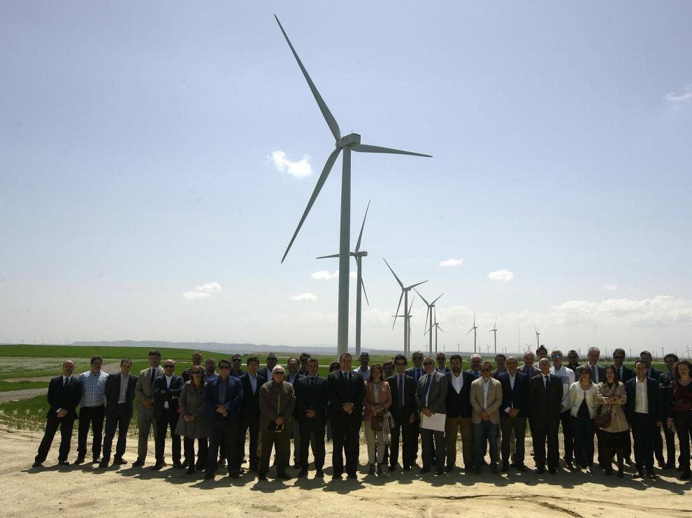 Representantes de las empresas participantes en la construcción y gestión del parque 'Valiente' con los aerogeneradores al fondo