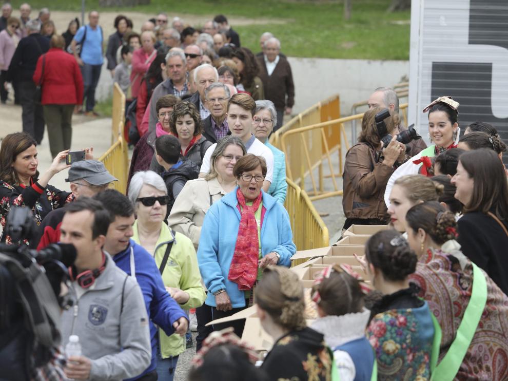 Cientos de oscenses han hecho fila pacientemente para recoger unas de 1.700 tortas con huevo duro que se repartían