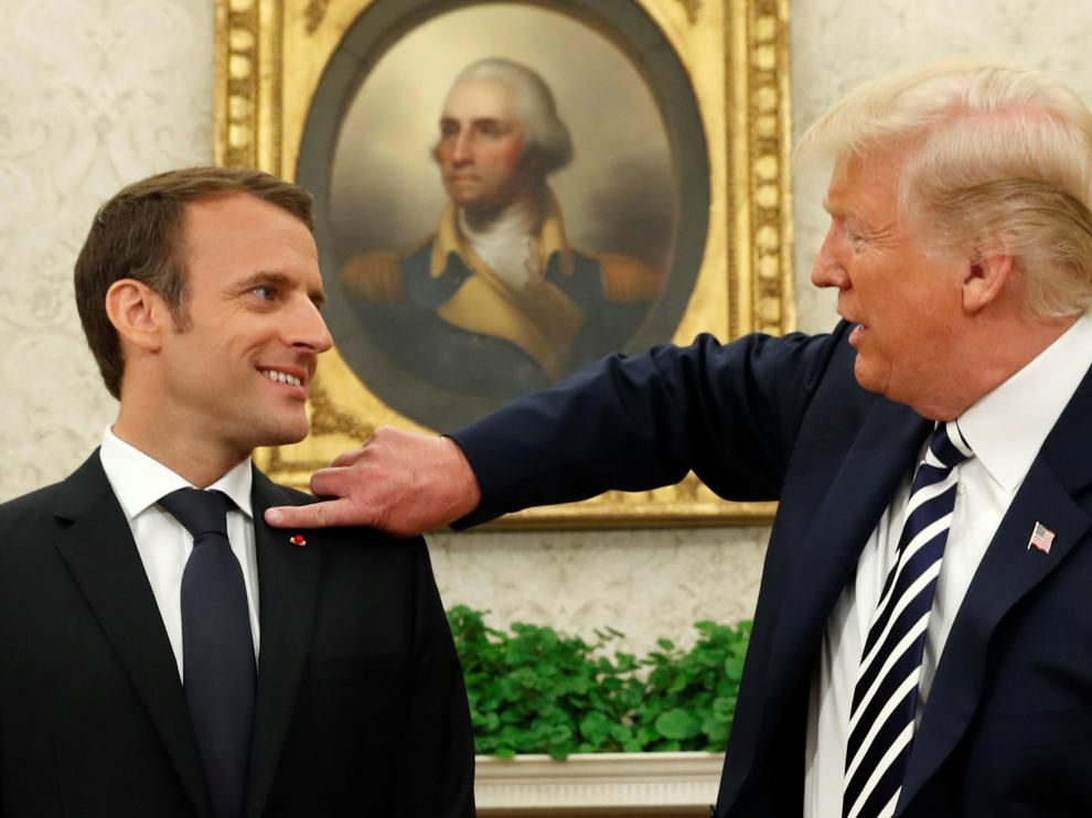 Momento en el que el presidente estadounidense le quita la caspa de la chaqueta a Emmanuel Macron.