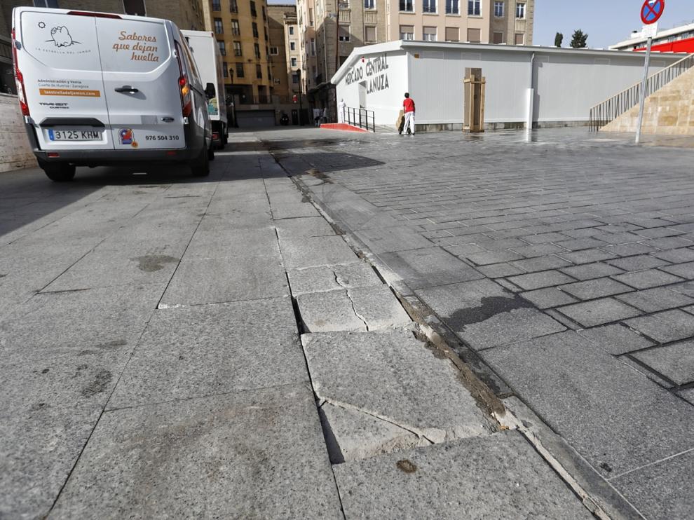 Baldosas de la calle Salduba destrozadas por el paso de camiones que cargan y descargan mercancía en la lonja provisional