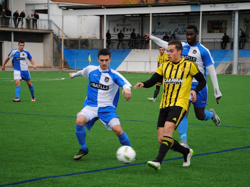 Pombo, del RZD Aragón, da un pase ante la presencia de dos jugadores del Tamarite