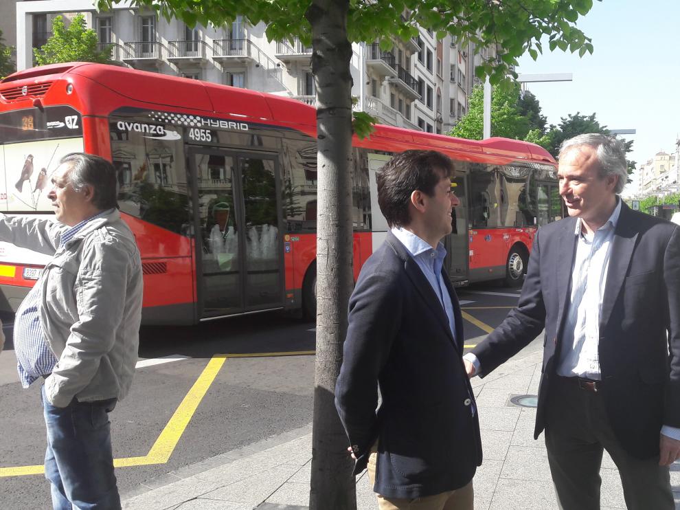 El portavoz del PP, Jorge Azcón, conversa este viernes con el edil de su grupo Sebastián Contín, en la parada del autobús de la plaza de España.