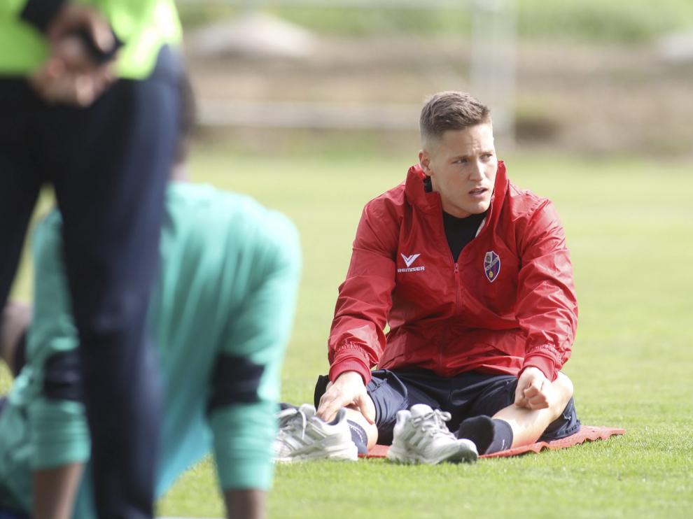 El portero Remiro, sobre el césped del Instituto Montearagón durante el entrenamiento que el Huesca ha completado este domingo tras vencer al Granada.