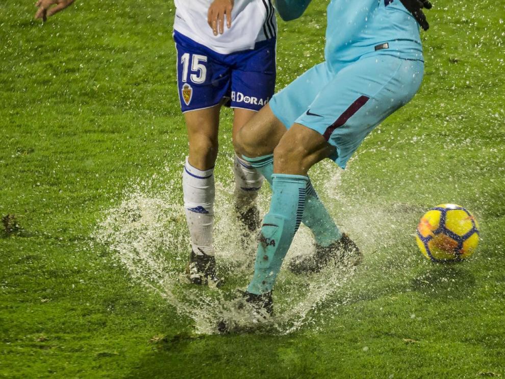 Imagen del partido Real Zaragoza-Barcelona B, con el balón y los jugadores atascados en el agua y el barro en la lluviosa noche de enero... en la que el equipo aragonés también se obturó peligrosamente.