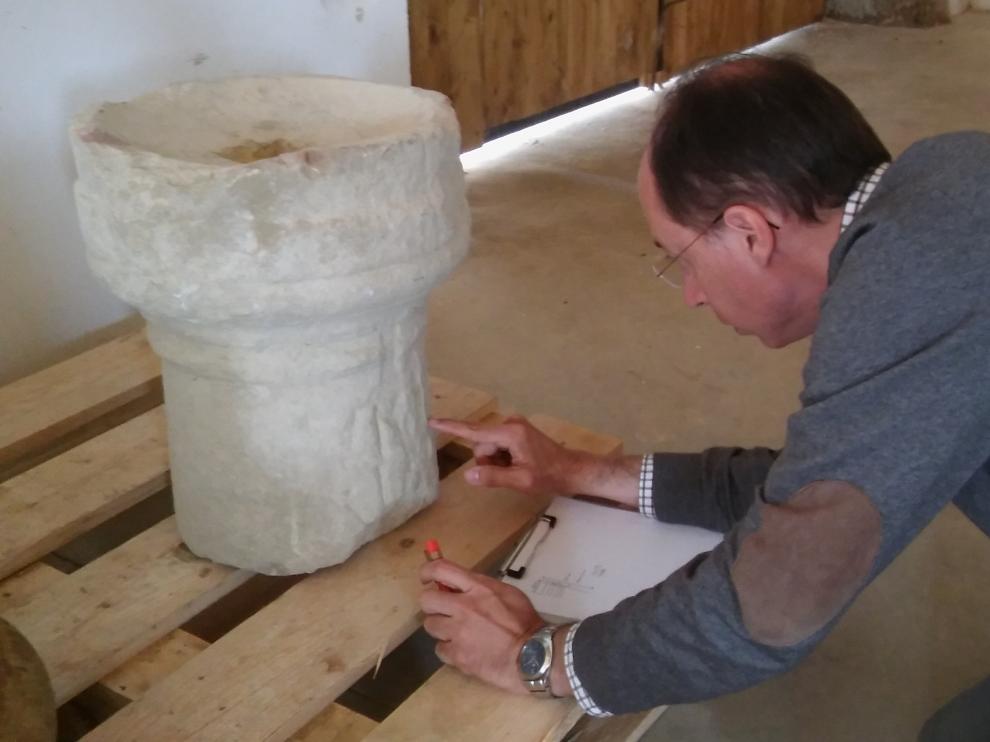 El arqueólogo e historiador Javier Andreu, director de los trabajos en Los Bañales, estudiando la pieza.