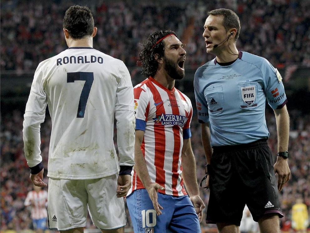 Carlos Clos Gómez, en un partido Real Madrid-Atlético Madrid, recibe la protesta de Arda Turan ante Cristiano Ronaldo.