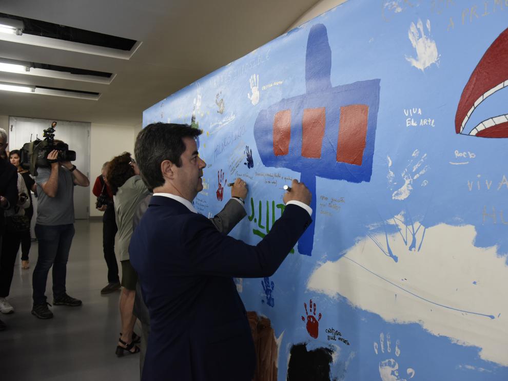 El alcalde de Huesca, Luis Felipe, escribe una frase en el mural colocado en el interior del Palacio de Congresos con motivo de Diversario.