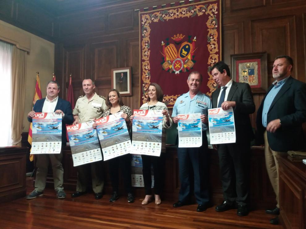 Representantes del Gobierno de Aragón, Ayuntamiento y Ejército con los carteles de la jornada.