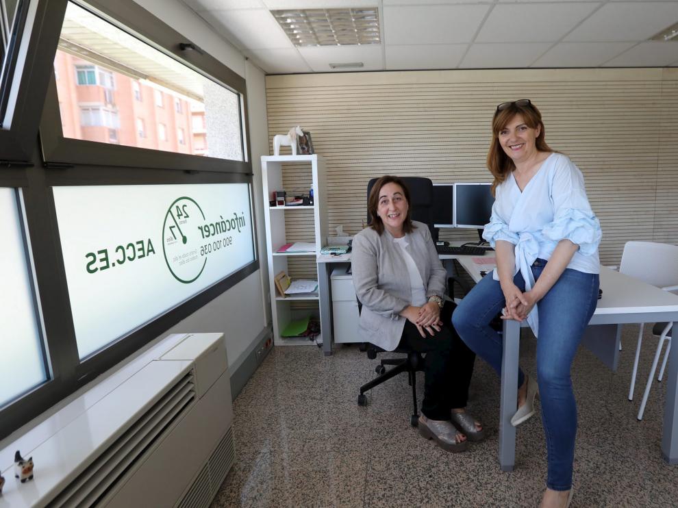 La presidenta de la AECC en Huesca, Aurora Calvo, y la psicóloga Ana Palomera en la nueva sede.