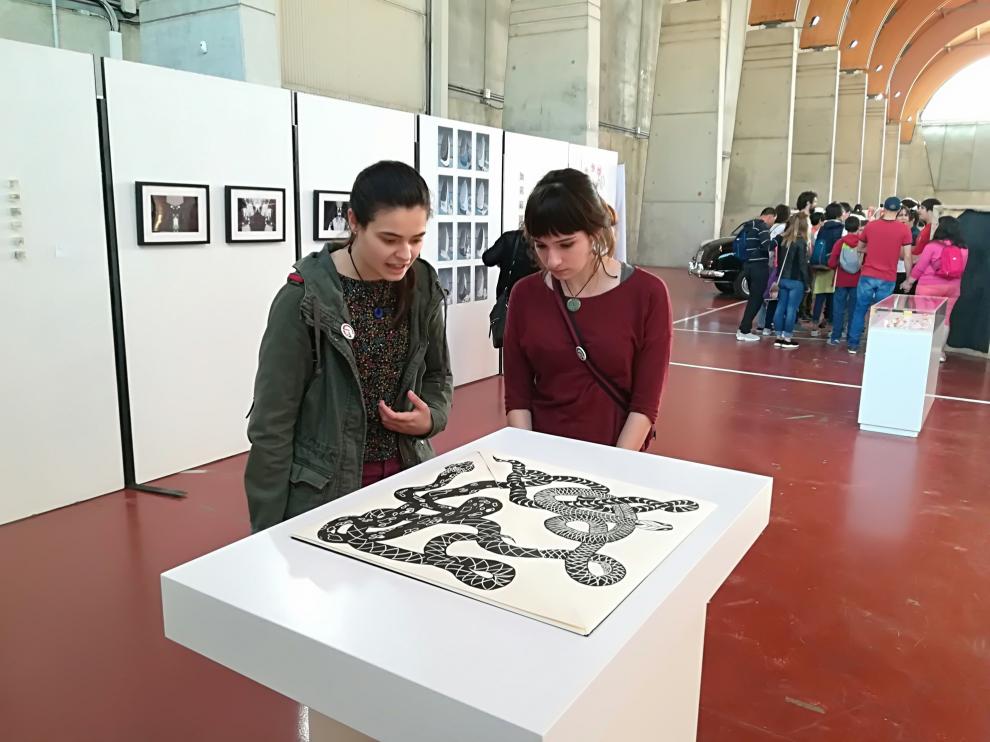 Dos jóvenes observan una de las obras de 'Festival Garbo', en el marco de la Feria Juventud Activa