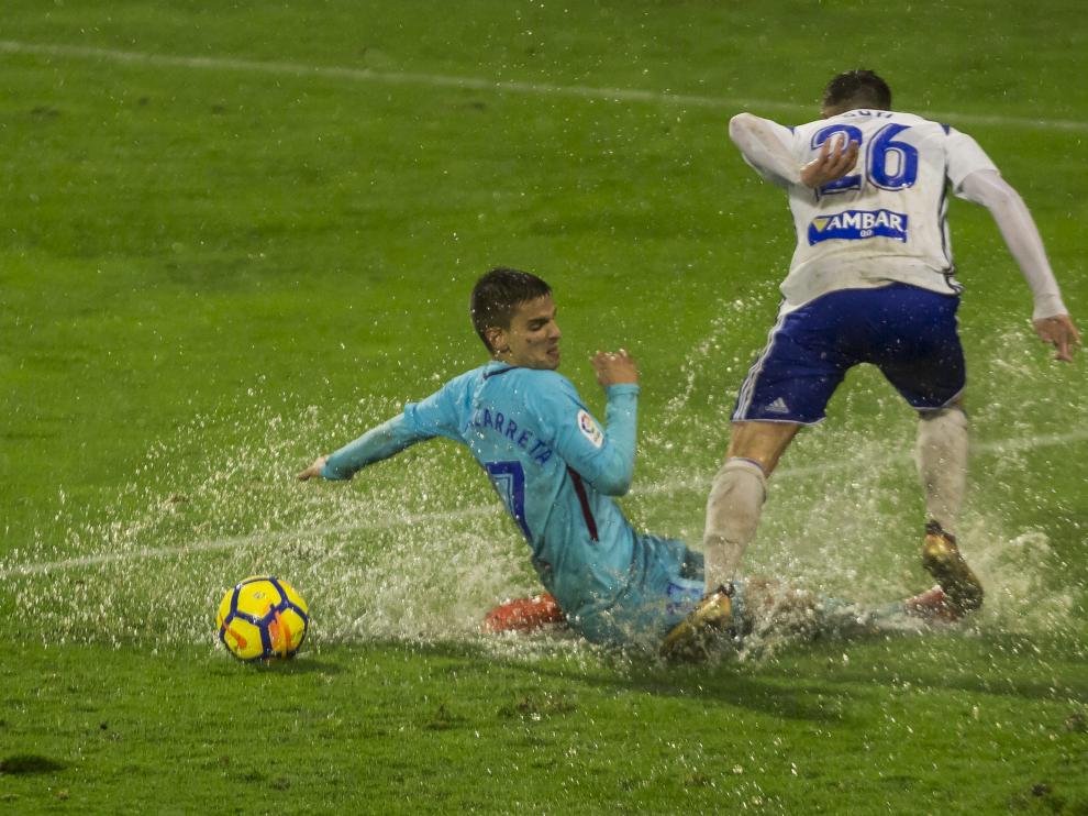 Raúl Guti pelea un balón con Ruiz de Galarreta bajo la lluvia, en el partido de ida en La Romareda