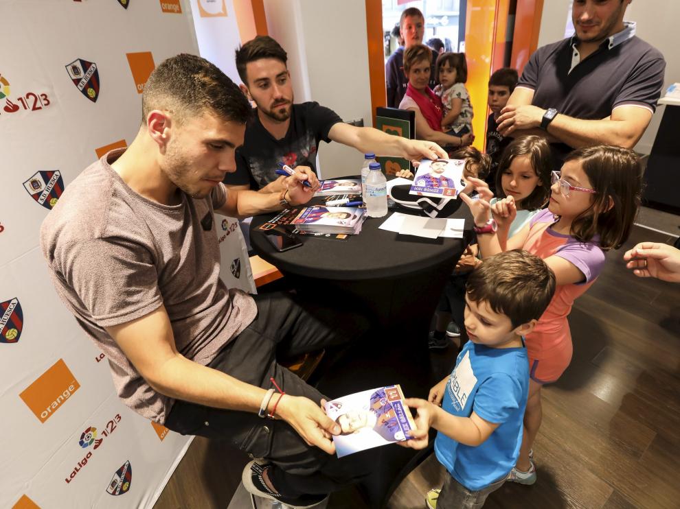 Gallar y Moi Gómez, rodeados de aficionados azulgranas este jueves en la tienda Orange de la capital oscense.