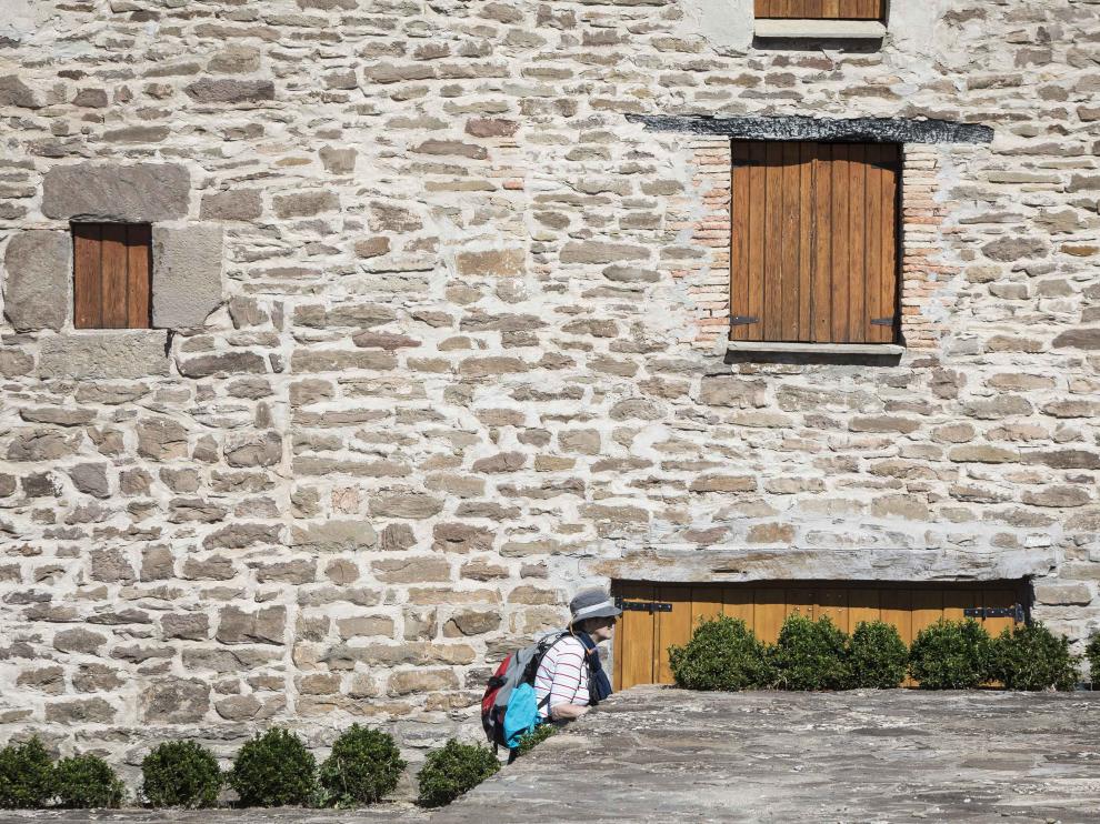 Una peregrina del Camino de Santiago se funde con el paisaje urbano de Undués de Lerda.
