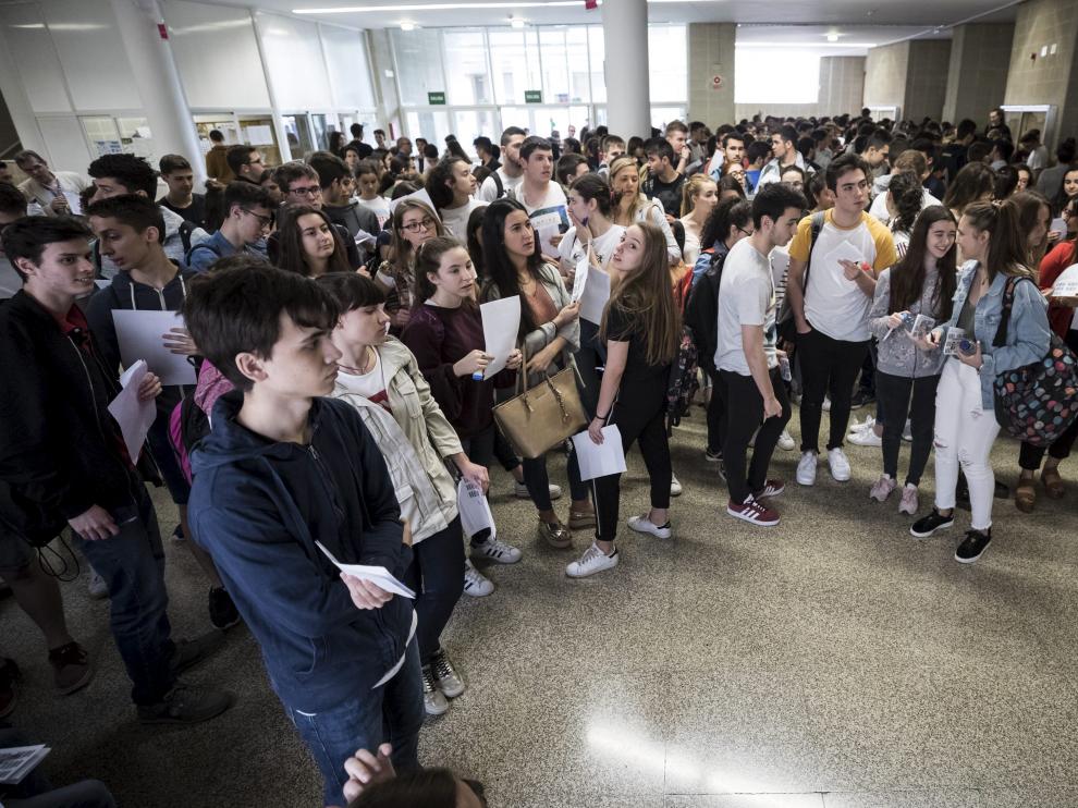 Un grupo de estudiantes esperan para entrar en el aula en la que se examinarán de una de las pruebas de la Evau