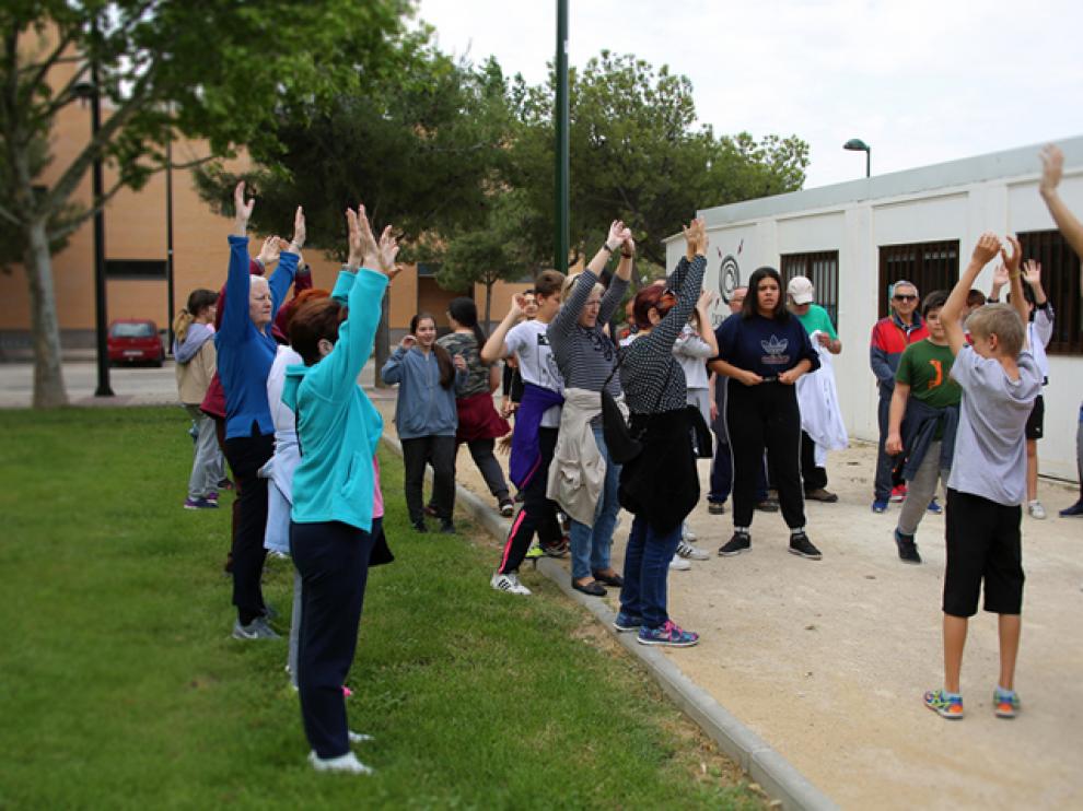 El grupo de paseos saludables y los alumnos del IES El Picarral, frente a la casa del barrio de Parque Goya