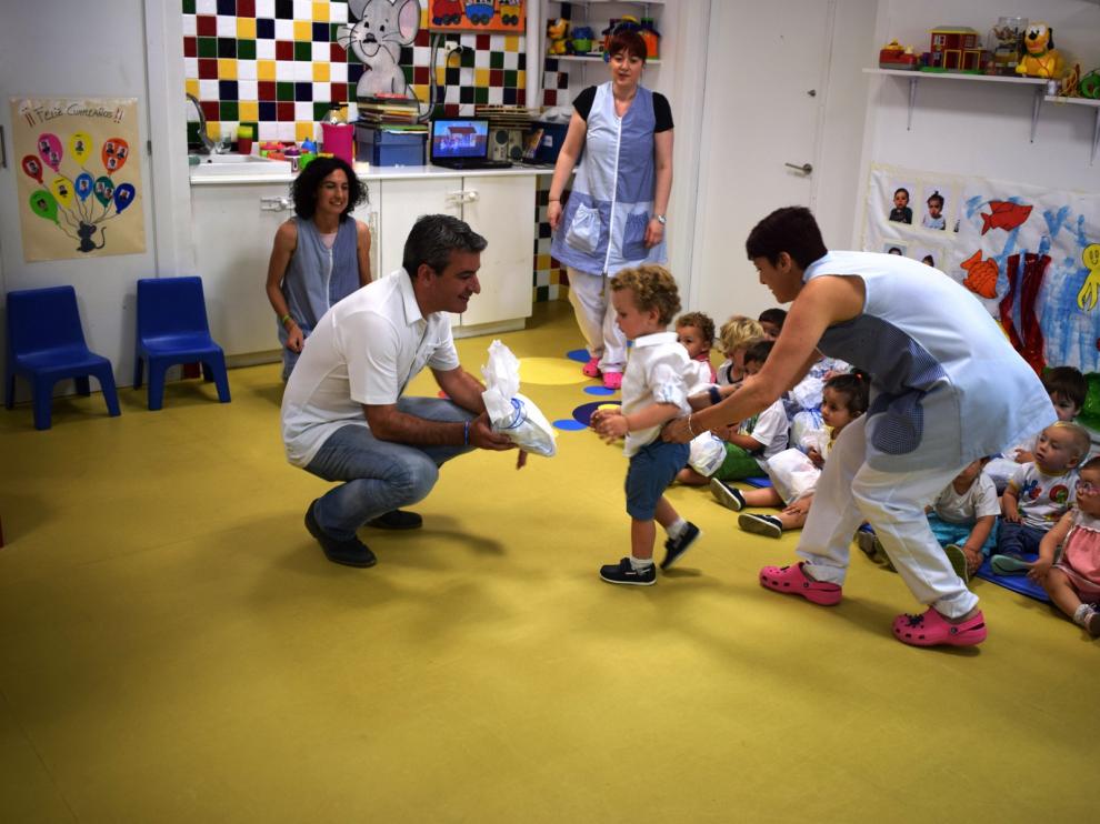 El alcalde y un concejal entregando los papelones a los alumnos de la escuela infantil