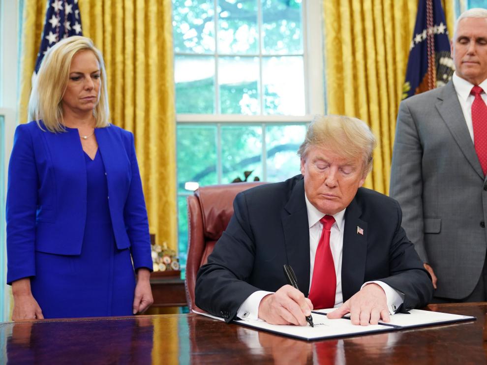 Donald Trump firmando la orden que permitirá a los niños quedarse con sus padres en centros de detención.