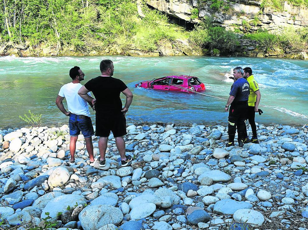 El coche quedó varado e incrustado en unas piedras en medio del cauce tras caer desde una altura de unos tres metros.