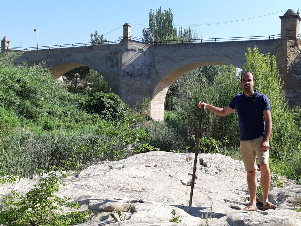 Javier García Calatrava, alcalde de Castelserás, con el puente al fondo.