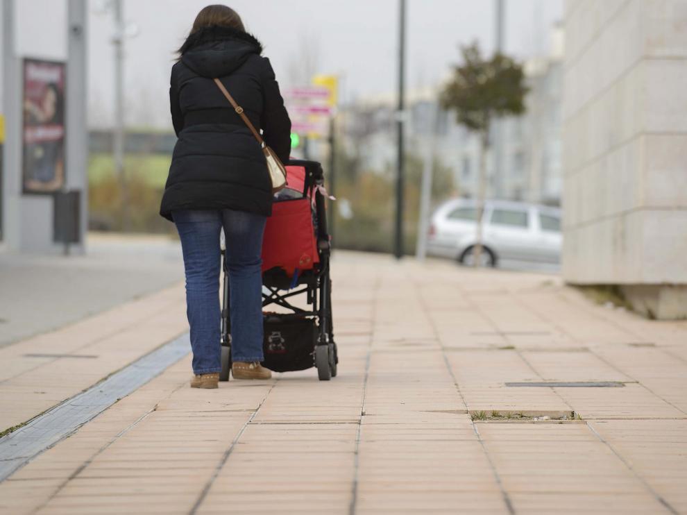 Imagen de archivo de una zaragozana paseando a su hijo.
