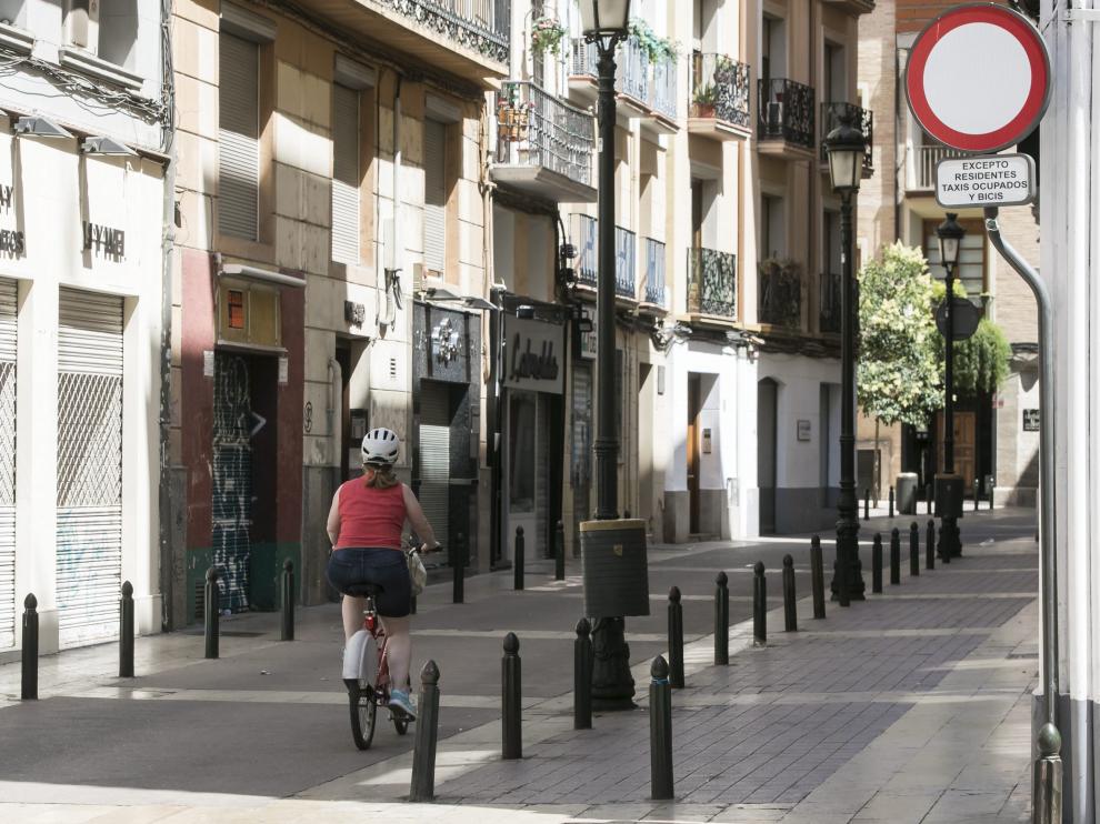 Una ciclista, este martes, a su paso por la calle de Méndez Núñez, junto a una de las señales que permite el acceso de bicicletas y que se retirará en los próximos días.