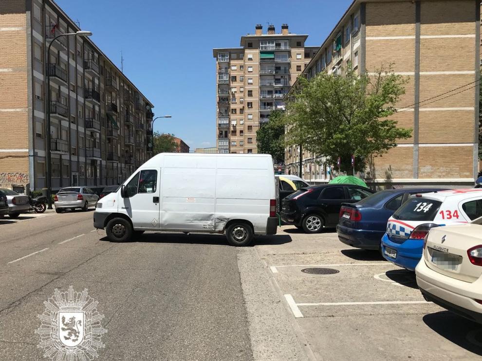 La fotografía muestra la furgoneta en medio de la calzada y el coche patrulla en la plaza de minusválidos.