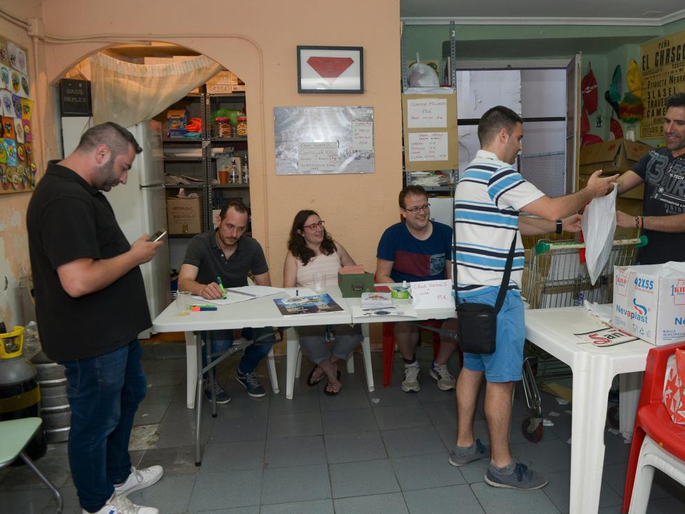 Los socios de la peña El Chasco recogen su equipación en el local de la agrupación.