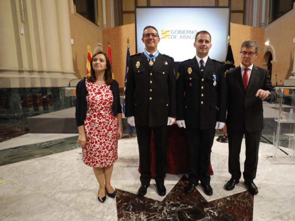 La delegada del Gobierno en Aragón, Carmen Sánchez, y el consejero de Presidencia, Vicente Guillén, con los policías condecorados José Antonio Lorente y Ramón Sanz.