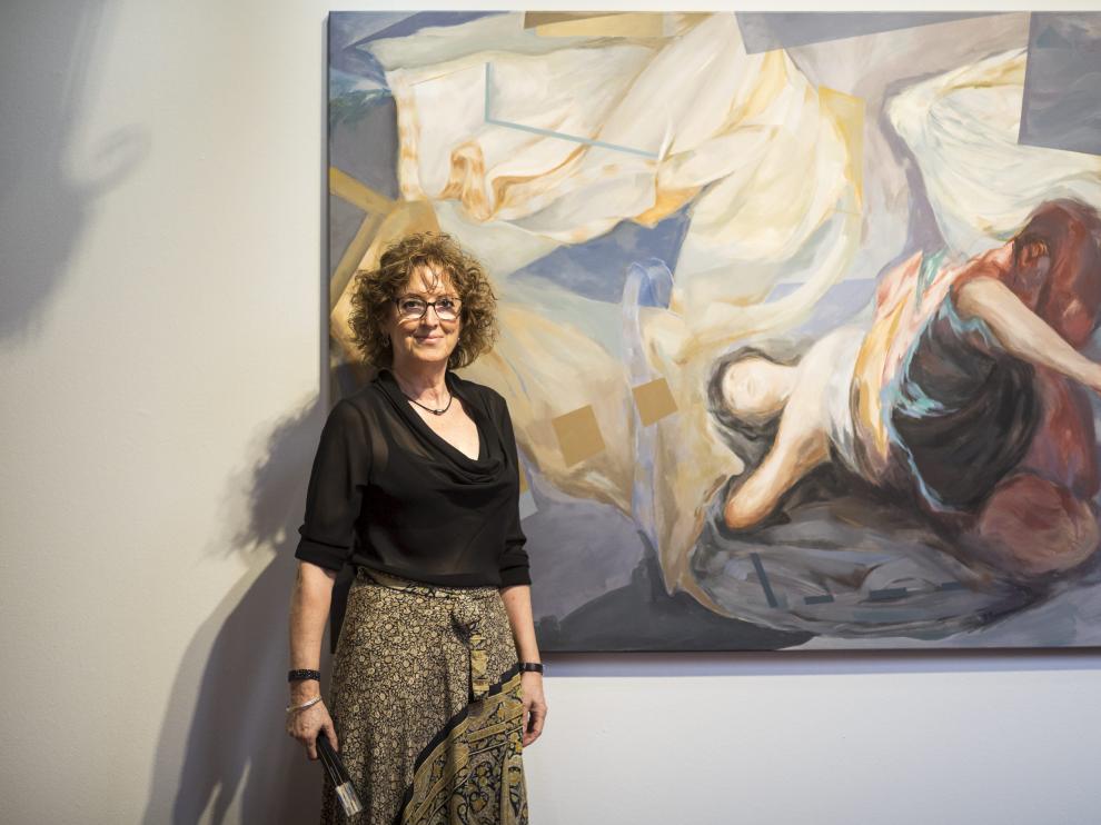 La pintora Carmen Pérez-Ramírez, ante sus obras, en la galería de arquillos del palacio de Sástago.