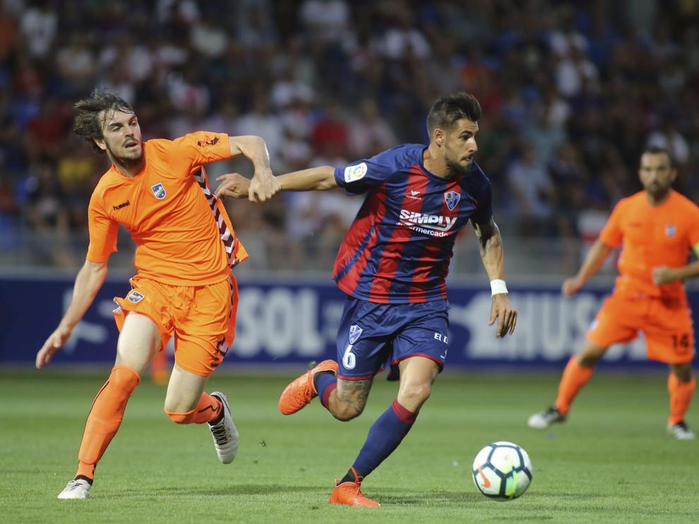 Eugeni, a la izquierda, le disputa el balón a Luso en el Huesca-Lorca de la pasada temporada.