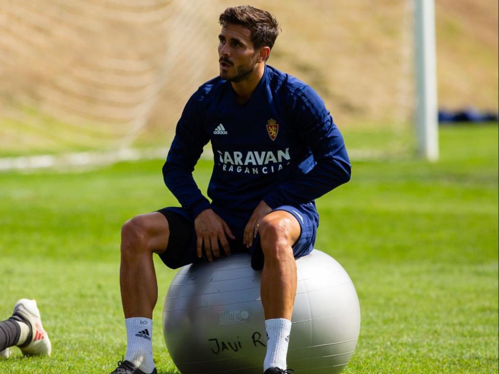 Javi Ros, subido en el balón grande sobre el que llevan a cabo los estiramientos los futbolistas del Real Zaragoza.