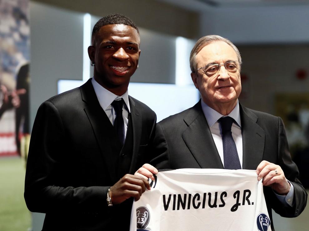 Vinicius Junior sujeta su nueva camiseta, sin dorsal, junto al presidente Florentino Pérez