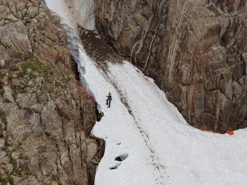 Especialistas de los grupos de montaña durante el rescate del montañero fallecido ayer al caer 100 metros por una canal de nieve.