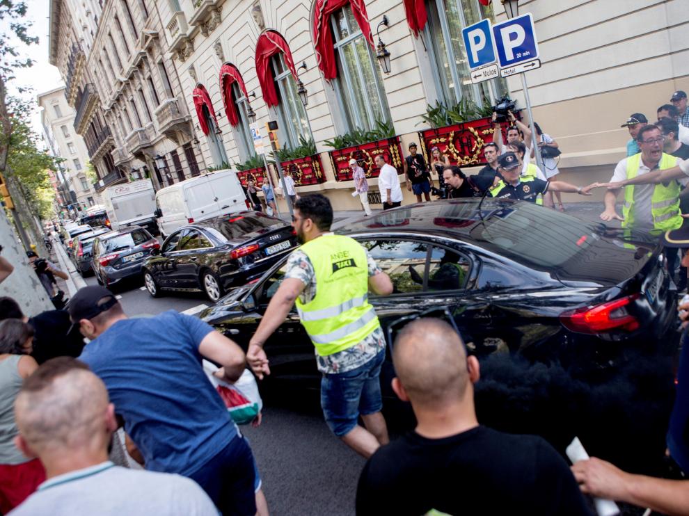 Un grupo de taxistas increpando a un coche frente al hotel Palace de Barcelona.