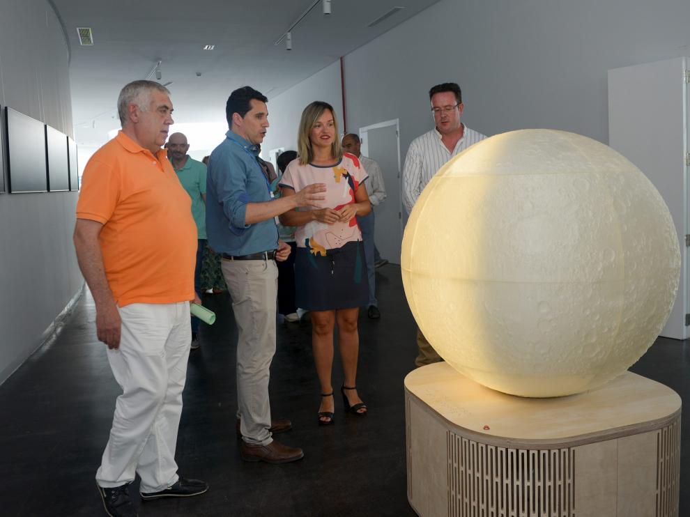 El director del Cefca, Javier Cenarro, explica a la consejera Pilar Alegría la réplica de la Luna en Galáctica.