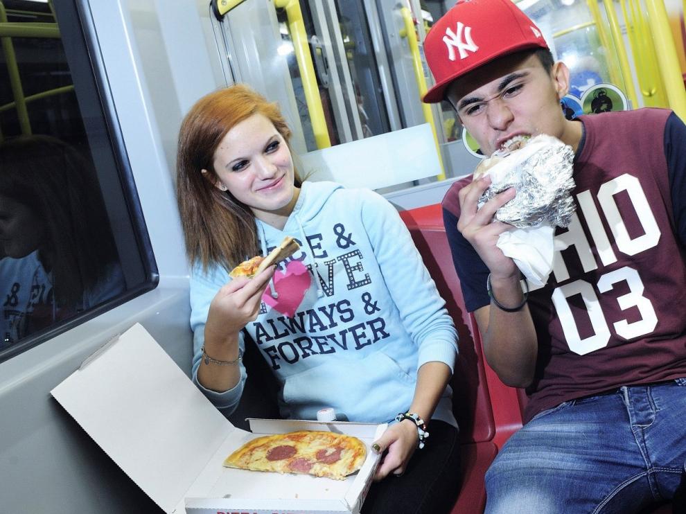 Dos pasajeros en la línea más antigua de Viena, la U6, comen Pizza y Kebab