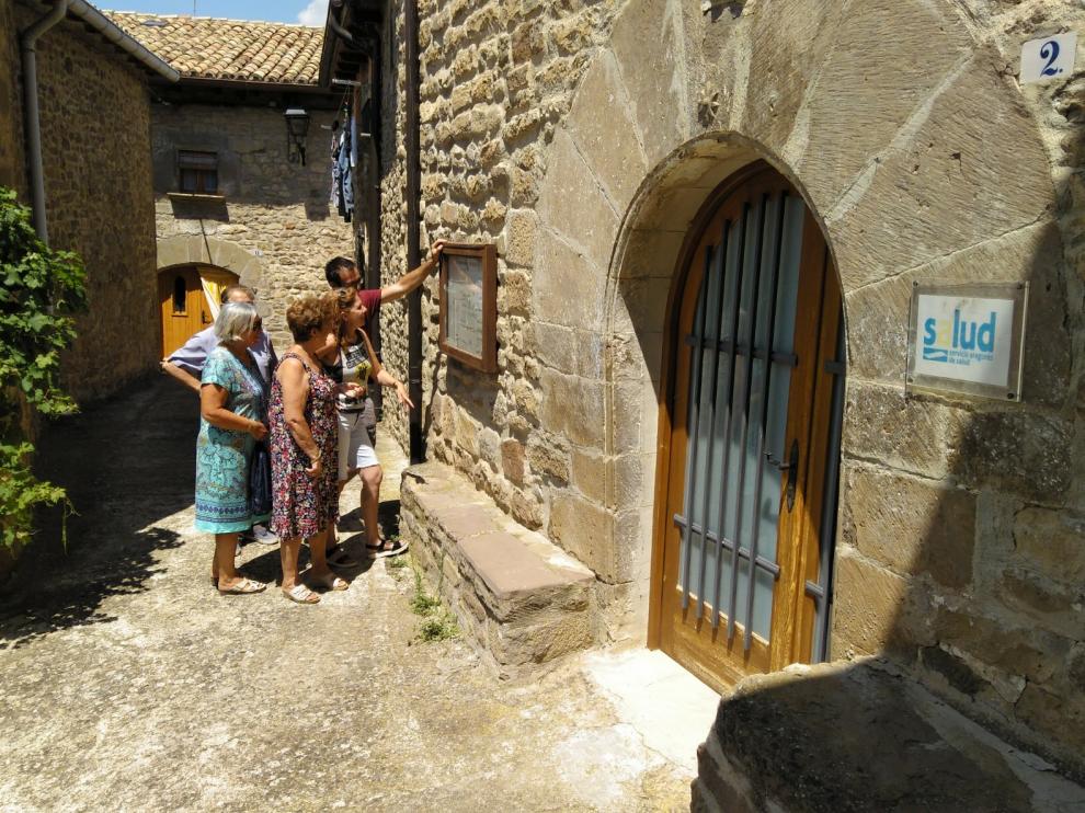 Vecinos de Urriés observan el horario provisional del médico en el tablón del consultorio.