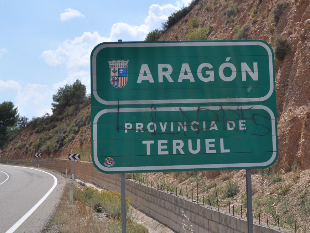 Cartel con la pintada ofensiva en la entrada a la provincia de Teruel.