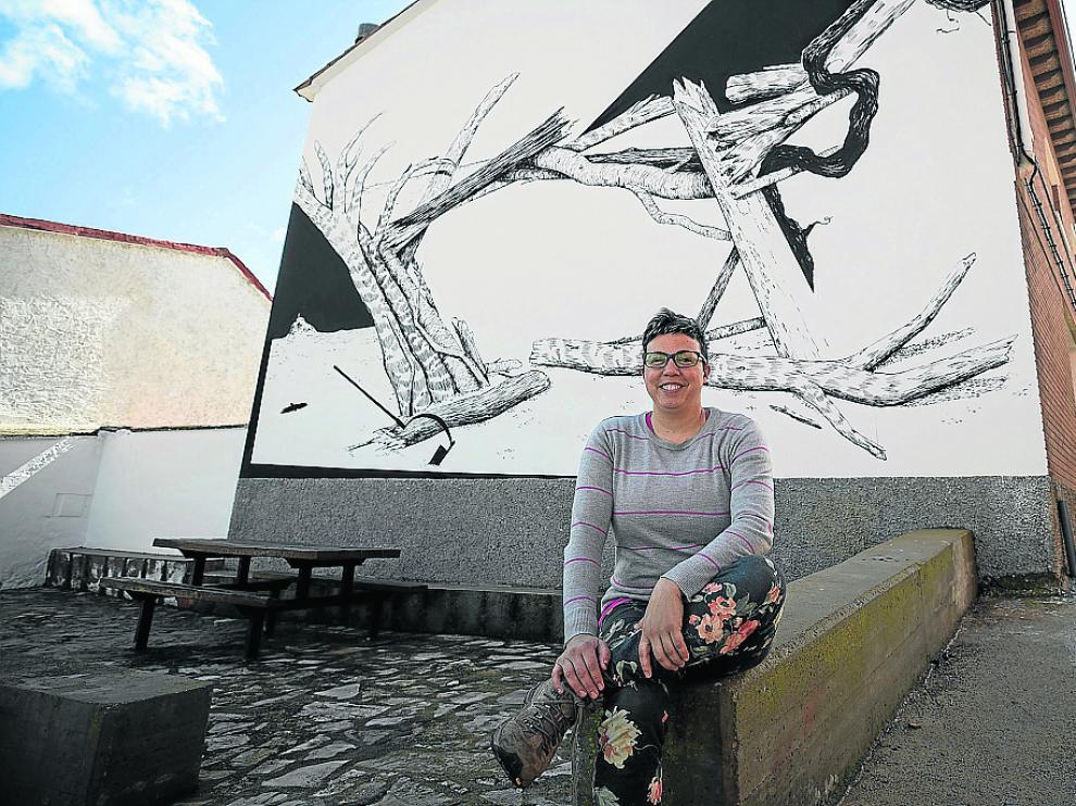 La alcaldesa de Aladrén, Marta Blanco, ante uno de los murales del municipio.
