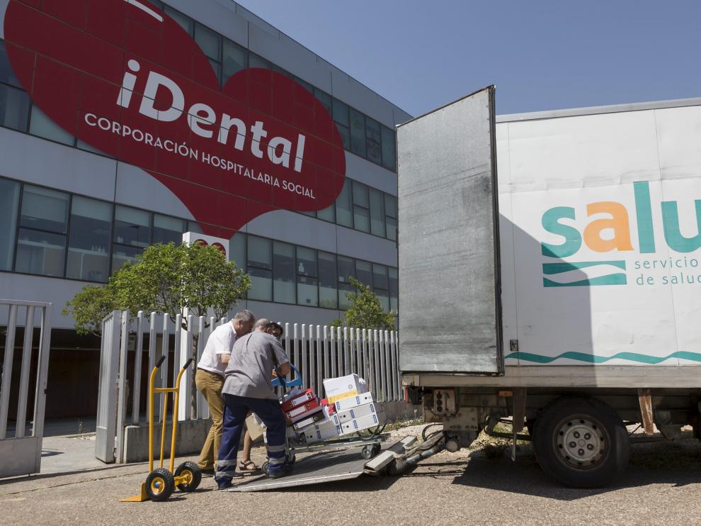 Unos operarios suben a la furgoneta del Salud los expedientes clínicos de los pacientes de Idental