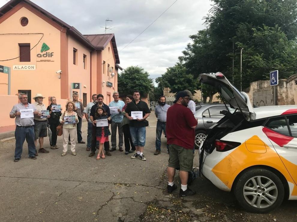 Miembros de la plataforma, con carteles reclamando el cercanías en la estación de Alagón.