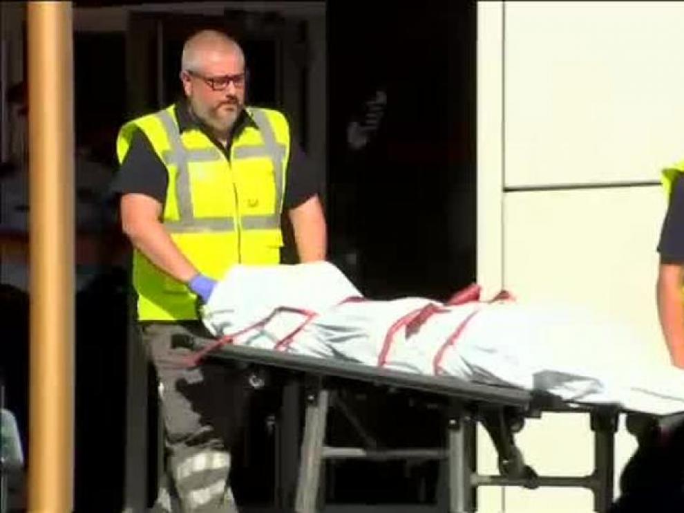 Momento del levantamiento del cadáver del hombre abatido en la comisaría de Cornellà
