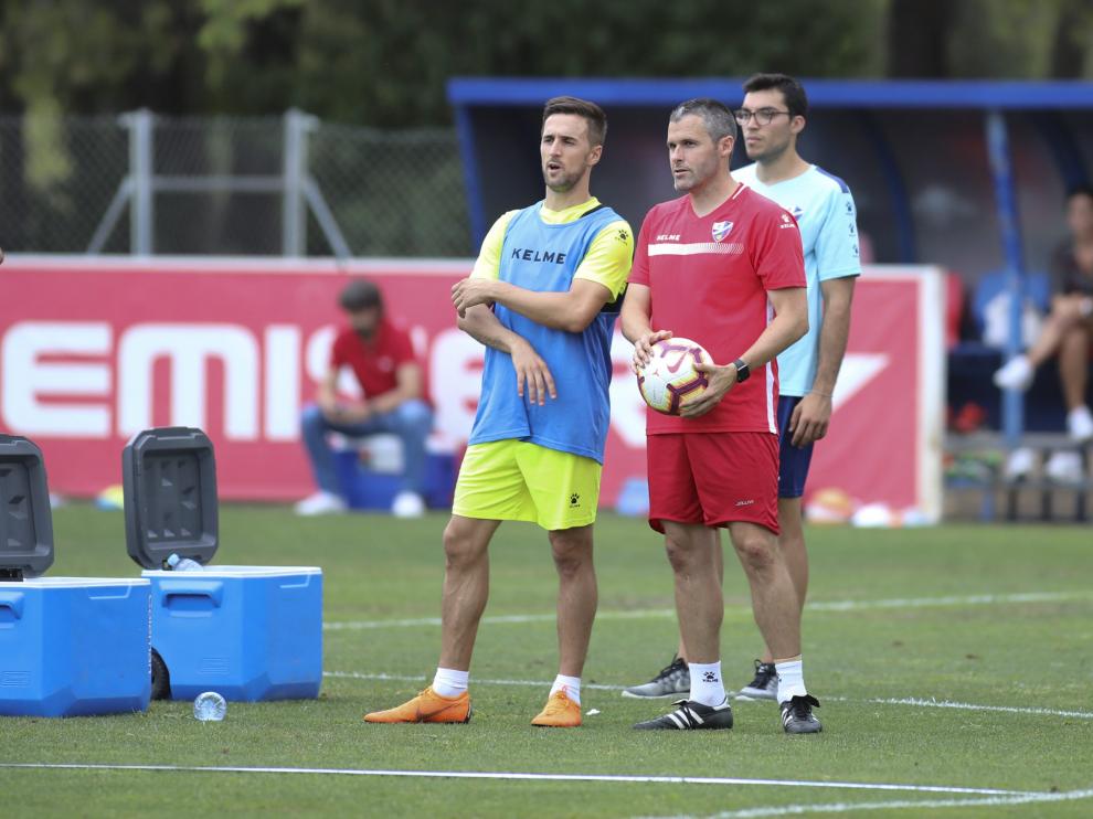 Miramón dialoga con uno de los técnicos, Pablo Orbaiz, durante el entrenamiento de esta tarde del Huesca en el IES Pirámide.