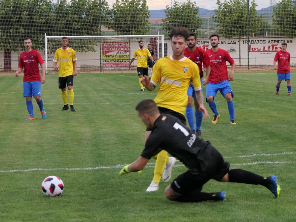 El jugador del Ejea Héctor Otín intenta salvar al portero del Cariñena en un partido amistoso de pretemporada