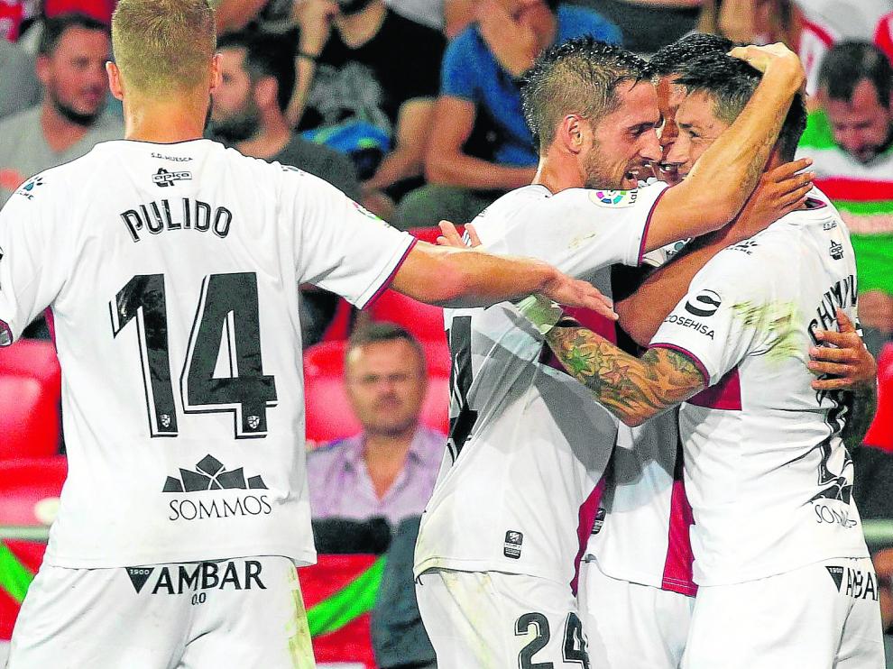 Jorge Miramón, autor del primer tanto, festeja con Chimy Ávila y otro compañero, en presencia de Pulido, el segundo gol oscense.