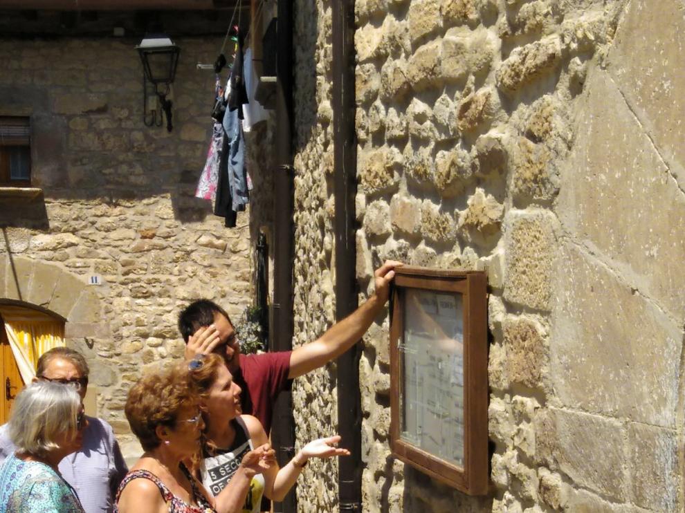 Vecinos de Urriés miran el cartel con los nuevos horarios de atención médica