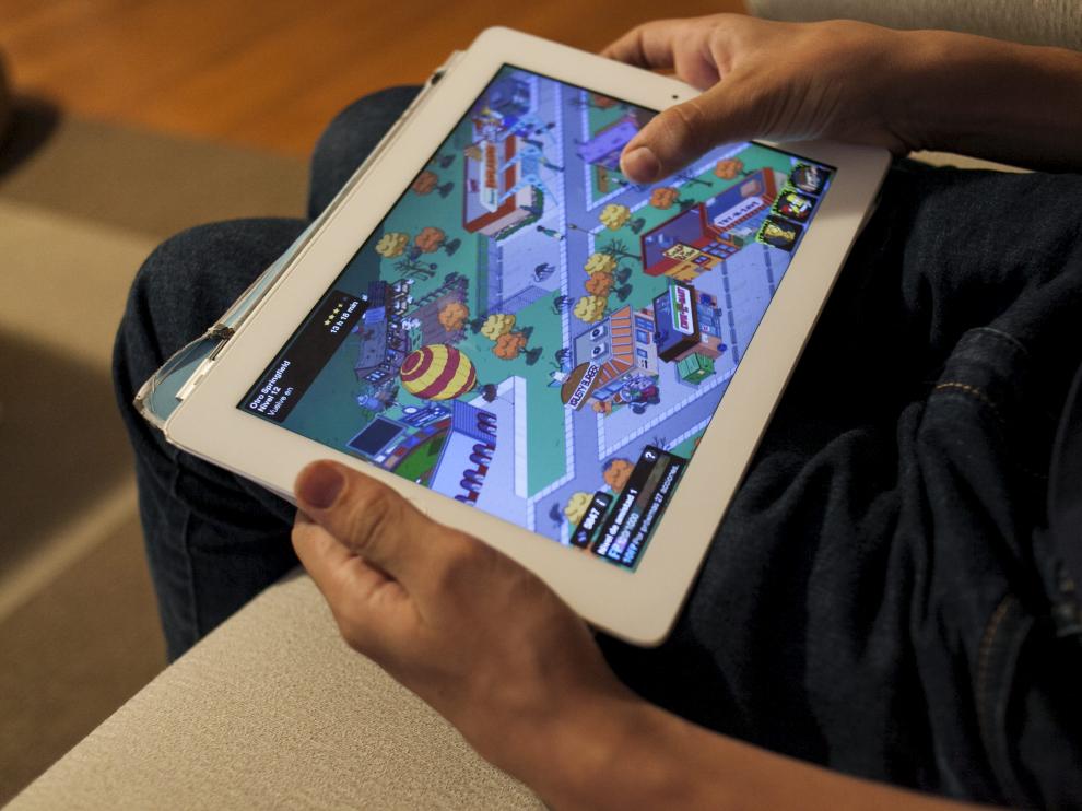 Un joven con una tablet jugando