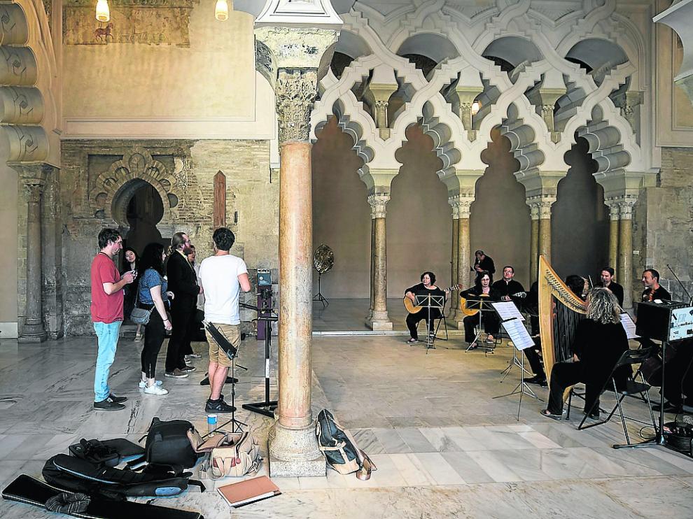 Néstor Romero (izquierda) junto a su equipo y la orquesta (derecha), el sábado en la Aljafería.