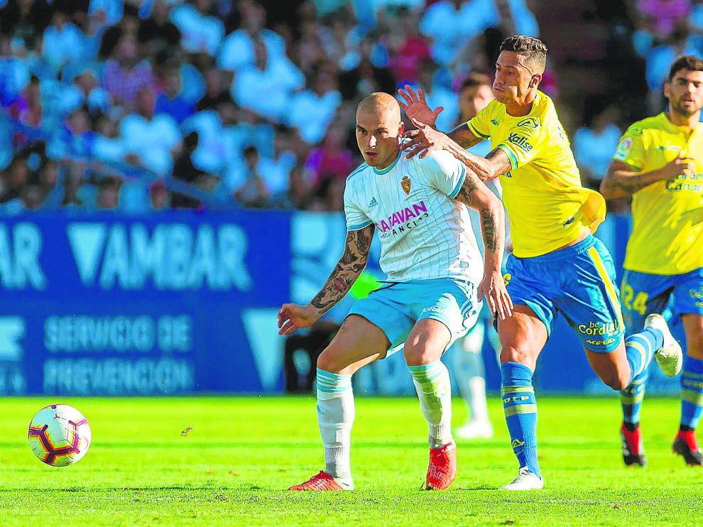 Maikel Mesa, de Las Palmas, trata de frenar infructuosamente a Jorge Pombo.