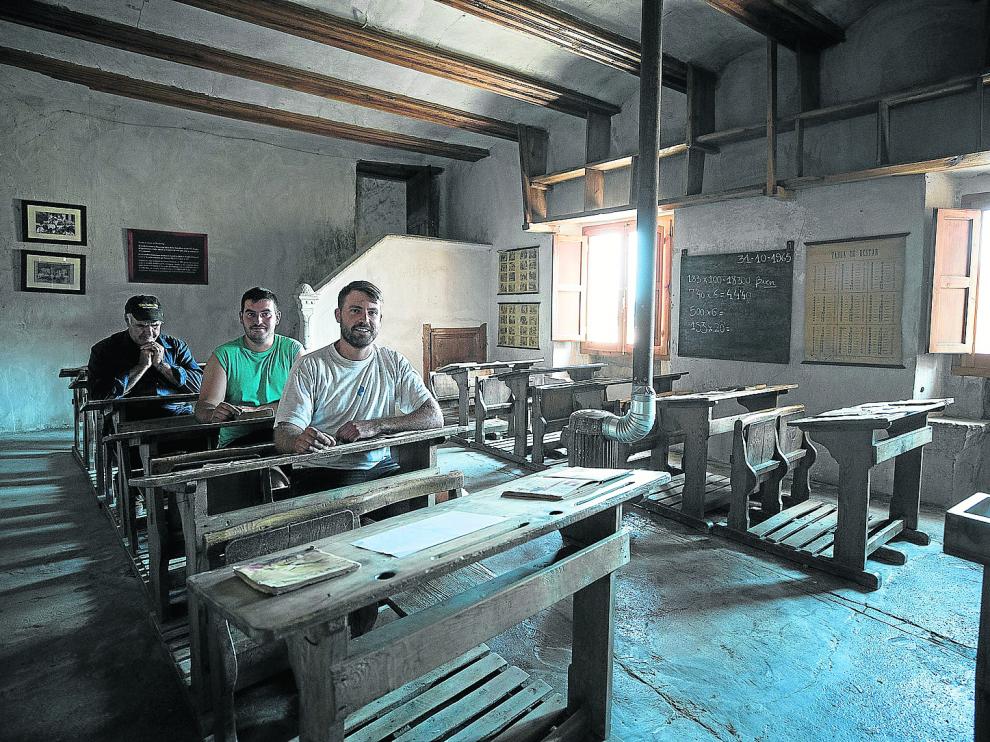 Israel Monterde, Ángel López y César Buj, en los pupitres del museo que recuerda a la escuela del pueblo.